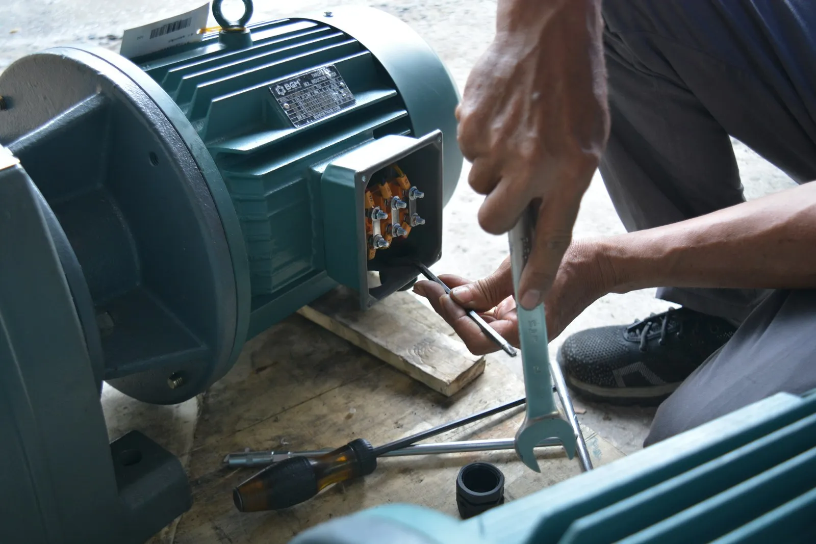 Técnico realizando teste de isolação em motor elétrico na bancada